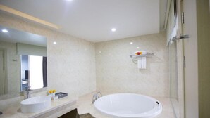 Uma casa de banho moderna com uma banheira grande, uma pia dupla e um espelho.