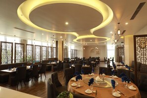 A restaurant with round tables, chairs, and modern lighting fixtures. - Central Hotel Thanh Hoa (Thanh Hoa)