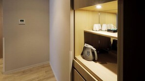 A kitchenette with a kettle, a coffee maker, and a tray of cups. - JR Inn Sapporo N2 (Sapporo)