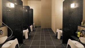 A modern bathroom with black marble sinks, white toilets, and a tiled floor. - JR Inn Sapporo N2 (Sapporo)