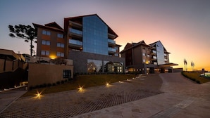 A modern hotel with a multi-story structure, a covered outdoor area, and a paved walkway. - Laghetto Viverone Canela (Canela)