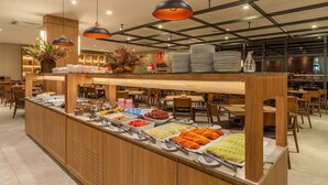 A buffet area with various food items and a seating area with tables and chairs. - Laghetto Viverone Canela (Canela)