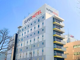 A multi-story hotel building with the name "Super Hotel" prominently displayed on the facade.