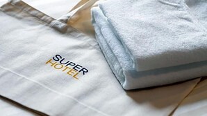 A folded towel and a white tote bag with 'SUPER HOTEL' text. - Super Hotel Okayama (Okayama)