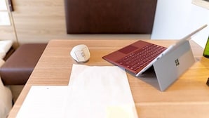A laptop on a wooden table with a mouse, a notebook, and a smartphone. - Super Hotel Okayama (Okayama)