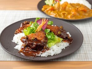 A plate of food with rice, a dark sauce, and a garnish. - Super Hotel Okayama (Okayama)