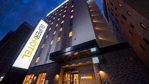 A SuperHotel with a modern design, featuring a prominent sign, a brick facade, and a visible entrance. - Super Hotel Okayama (Okayama)