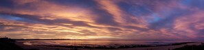 A coastal landscape with a sunset and a beach in the foreground. - Seashells Holiday Self Catering Apartments (Jeffreys Bay)