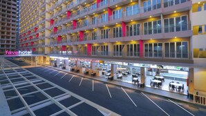A multi-story hotel with a modern design, featuring balconies, a ground-level restaurant, and a parking area. - Favehotel Nagoya (Batam)