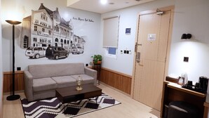 A modern living room with a sofa, coffee table, and a wall mural.