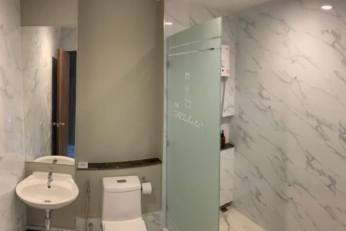 A bathroom with a sink, toilet, and a glass shower enclosure.