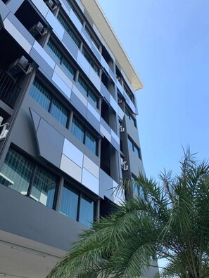 Edifício moderno com vários andares, balcões e amplas janelas.