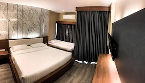 A hotel room with two beds, a wooden headboard, a flat-screen TV, and a marble-patterned wall. - The Chess Hotel (Rayong)