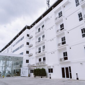Un immeuble à plusieurs étages doté d’une façade plate, de grandes fenêtres et de climatiseurs.
