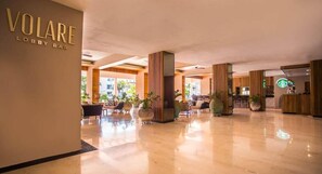 A lobby with a polished marble floor, a reception desk, and a Starbucks logo. - Marival Emotions Resort & Suites Riviera Nayarit by Mercure (Nuevo Nayarit)