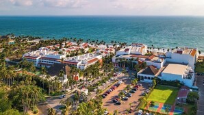 An aerial view of a coastal resort with multiple buildings, a parking lot, and a view of the ocean. - Marival Emotions Resort & Suites Riviera Nayarit by Mercure (Nuevo Nayarit)