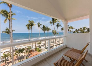 A balcony with a view of the beach, palm trees, and ocean. - Marival Emotions Resort & Suites Riviera Nayarit by Mercure (Nuevo Nayarit)
