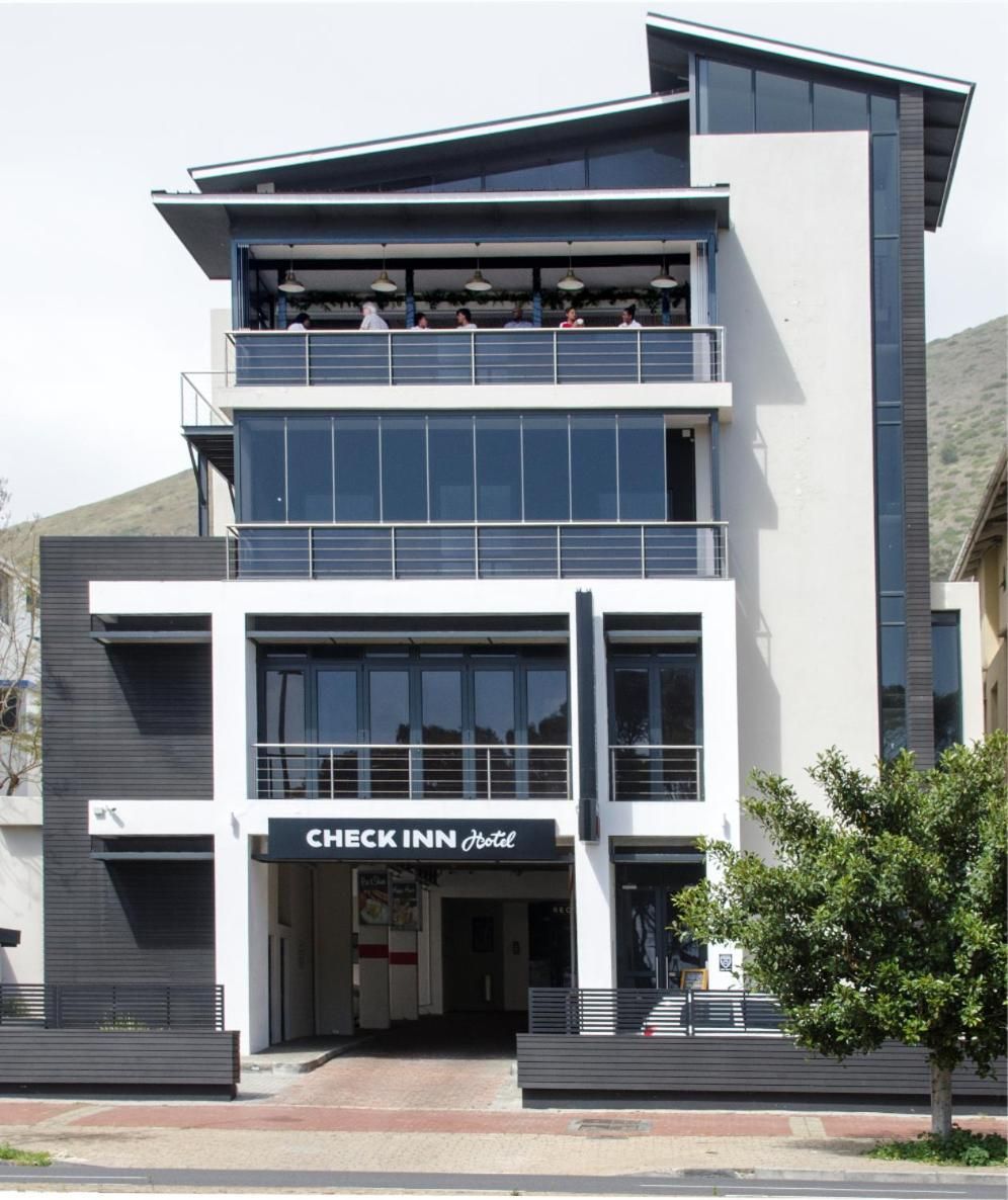 A modern hotel with a two-story structure, a balcony on the upper floor, and a visible entrance.