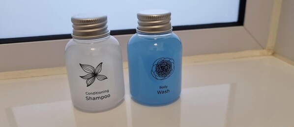 Dos botellas de champú sobre una superficie blanca.