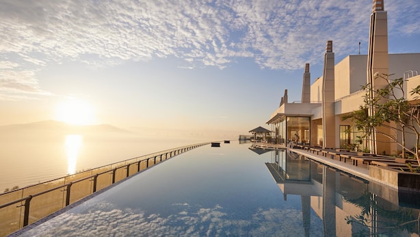 A modern hotel with a long infinity pool, a clear sky, and a view of the sea. - Da Nang Mikazuki Japanese Resorts and Spa (Da Nang)