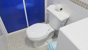 A bathroom with a white toilet, a blue shower enclosure, and a white sink. - Hotel Mexico Lindo (Santa María Huatulco)