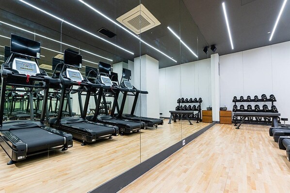 A gym with treadmills, weight benches, and dumbbells. - J-one Hotel and Resort (Cheongju)