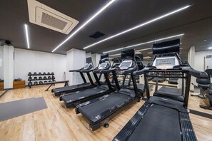 A gym with multiple treadmills, weight racks, and exercise equipment. - J-one Hotel and Resort (Cheongju)