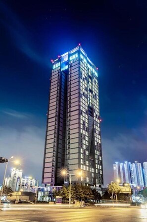 A tall, modern skyscraper with illuminated windows and a distinctive design. - J-one Hotel and Resort (Cheongju)
