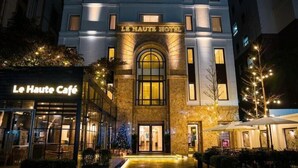 The exterior of Le Haute Hotel with a well-lit entrance and a cafe named Le Haute Cafe in front. - Viet 4 Seasons Hotel (Hai Phong)