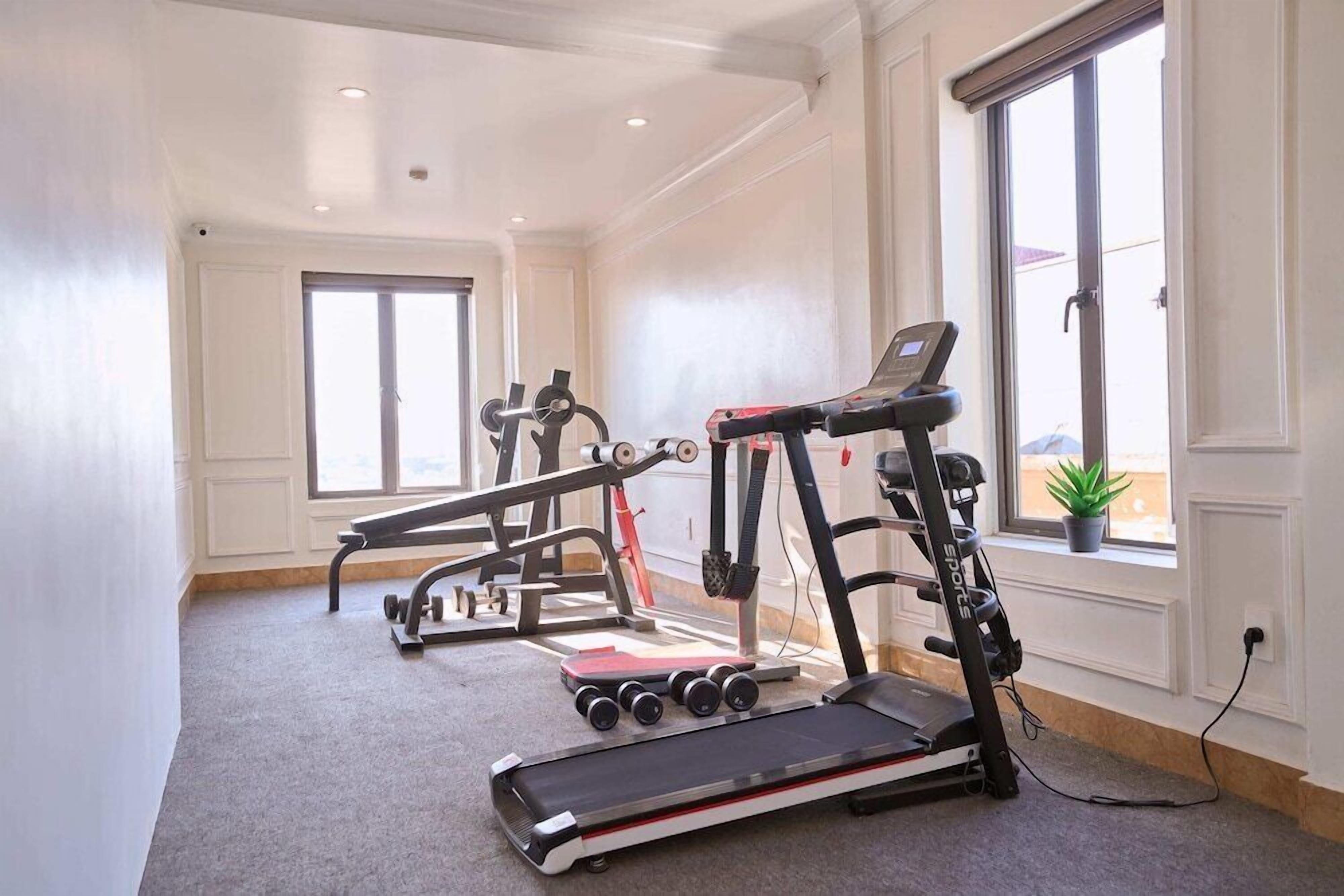 A gym with treadmills, a stationary bike, and a weight bench.