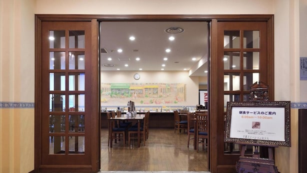 A restaurant with wooden doors, tiled flooring, and a mural on the wall.