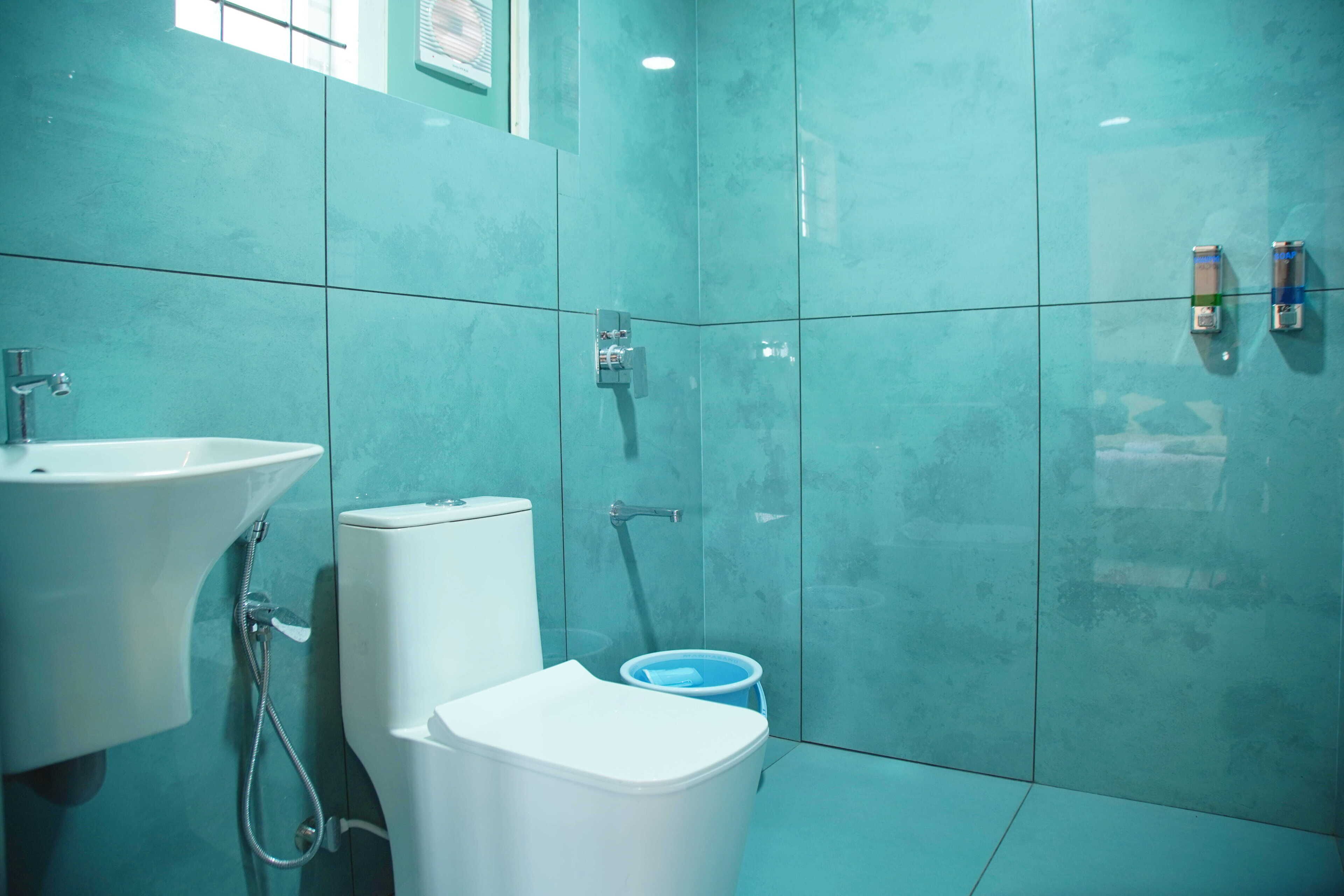 A bathroom with a white sink, toilet, and shower.