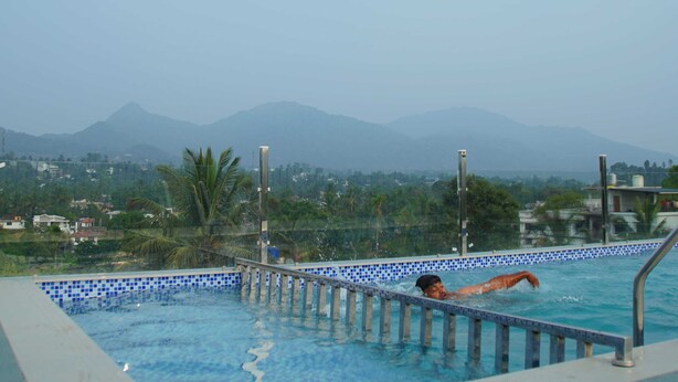 A swimming pool with a view of mountains and greenery in the background.