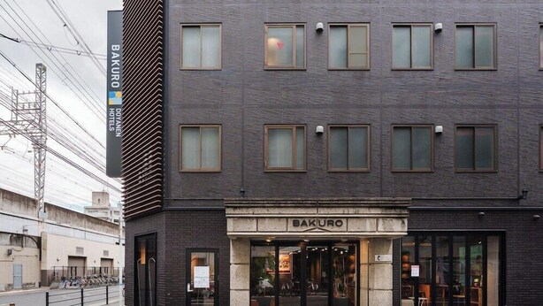 Un bâtiment moderne avec une enseigne indiquant « BAKURO DOYAN HOTEL » et une entrée en verre.