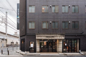 Un edificio moderno con un letrero que dice "BAKURO DOYAN HOTEL" y una entrada de vidrio.