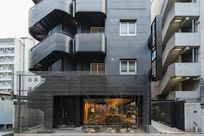 Un edificio moderno de varios pisos con balcones, una entrada visible y un letrero que indica 'BAYURO 3'.