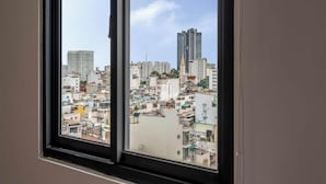 A window view of a densely packed urban area with various building heights and architectural styles. - Sazi Resin Hotel - Free Nails/hairwash (Ho Chi Minh City)