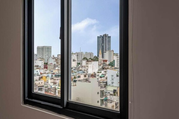 Blick aus dem Fenster auf dicht bebautes Stadtgebiet mit unterschiedlich hohen Gebäuden und verschiedenen Baustilen.