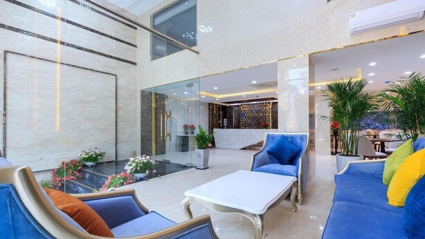 A spacious indoor area with seating arrangements, a reception desk, and a view of the outside. - Sazi Resin Hotel - Free Nails/hairwash (Ho Chi Minh City)