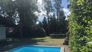 A swimming pool with a surrounding garden and a trampoline. - Holiday home, swimmingpool and beach (Nykøbing Sj)