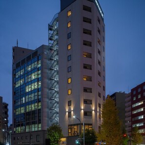A multi-story building with a prominent external staircase, large windows, and a visible fire escape. - Hotel Mid in Kuramae Ekimae (Tokyo)