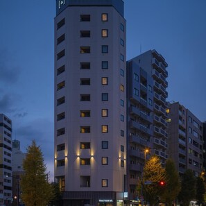 Um hotel moderno de vários andares, com varandas e uma entrada imponente.
