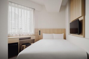 A hotel room with a bed, a desk, a chair, a TV, and a window with blinds. - Hotel Mid in Kuramae Ekimae (Tokyo)