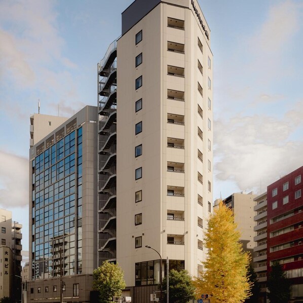 Een meerlaags gebouw met een modern ontwerp, met gevels van glas en beton en een opvallende centrale trap.