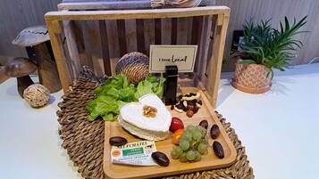A wooden display with a sign reading 'I love Local,' featuring a cheese, grapes, nuts, and a woven placemat.