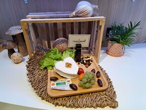 A wooden display with a sign reading 'I love Local,' featuring a cheese, grapes, nuts, and a woven placemat. - Ibis Styles Le Treport Mers Les Bains (Mers-les-Bains)