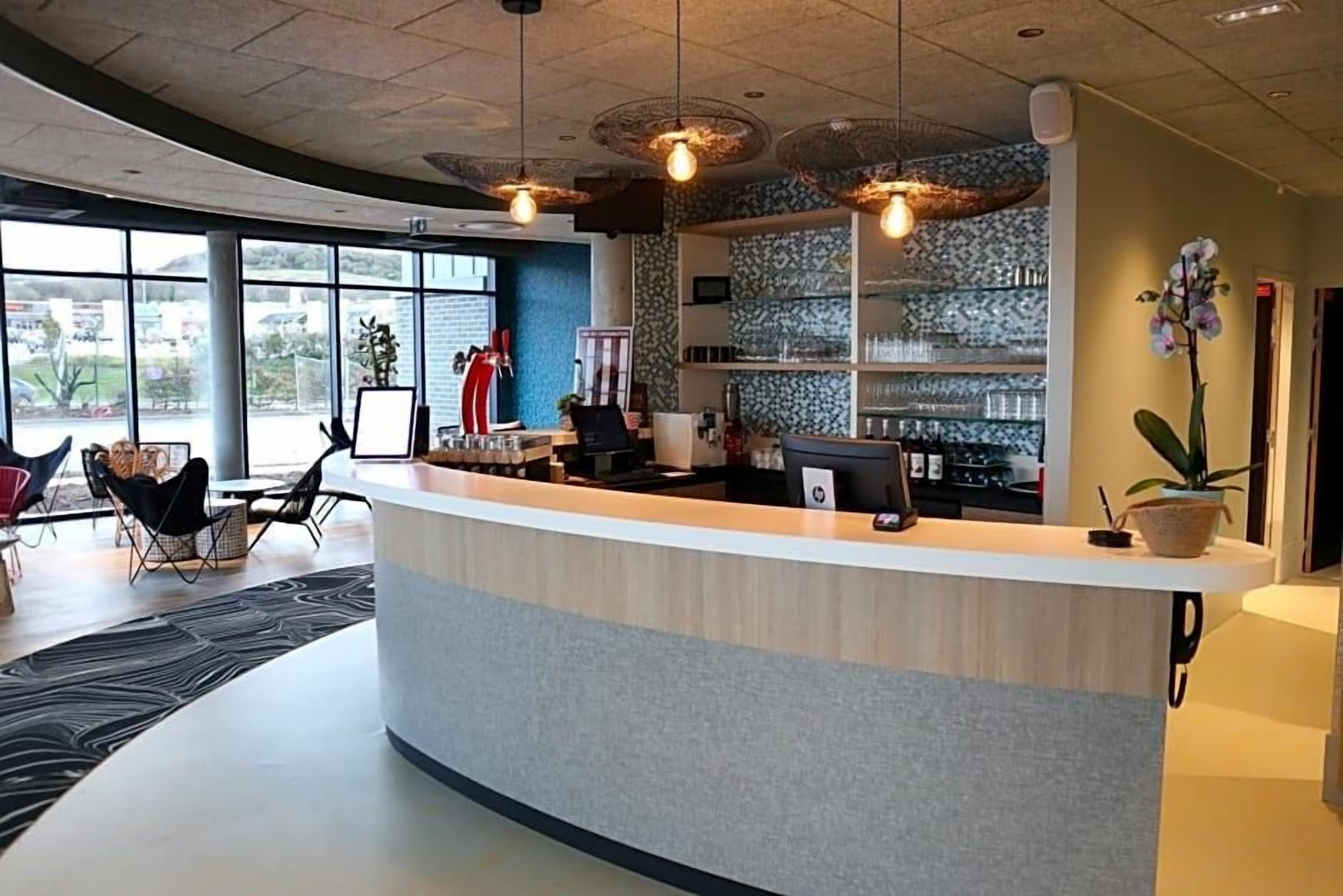 A reception area with a curved counter, a large window, and a potted orchid.