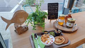 A table with food items, a wooden fish decoration, a plant, and a sign with text. - Ibis Styles Le Treport Mers Les Bains (Mers-les-Bains)