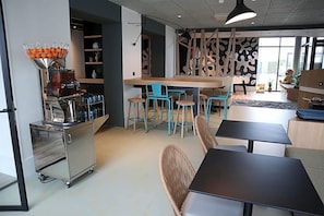 A modern cafe with a bar area, seating, and a coffee machine. - Ibis Styles Le Treport Mers Les Bains (Mers-les-Bains)