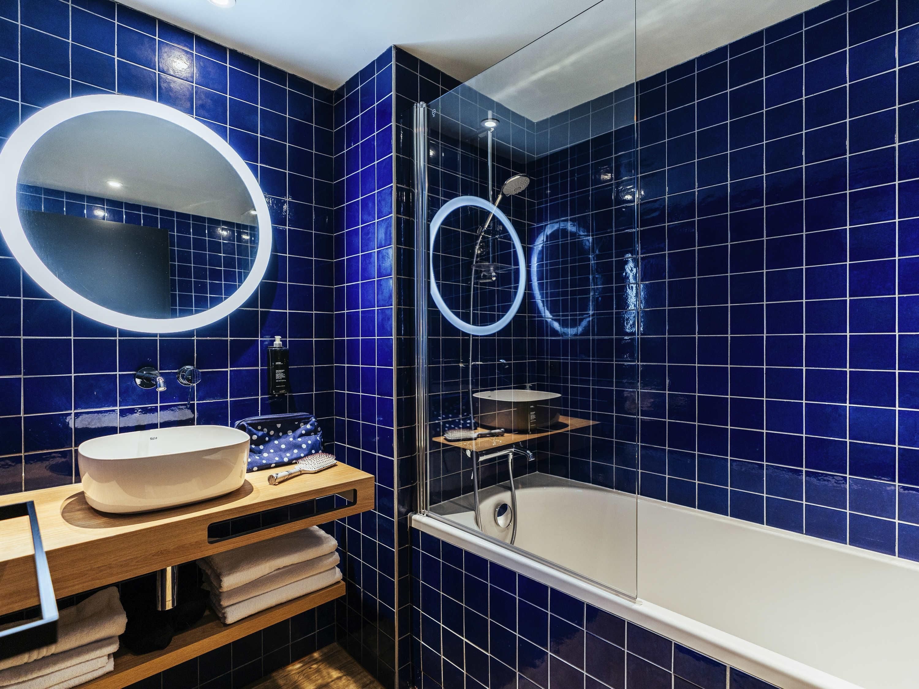A bathroom with a bathtub, a sink with a mirror, and a shower area.